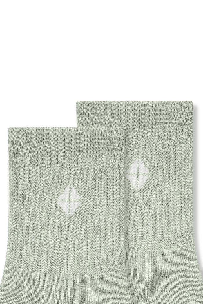 Top part of Adult Crew Socks in Thyme with Kyte Baby logo on a white background