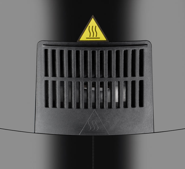 Nahaufnahme einer schwarzen Entlüftungsöffnung mit vertikalen Lamellen an der Unold Heißluftfritteuse XL. Darüber befindet sich ein dreieckiges Warnschild mit Hitzewellensymbol, das auf heiße Luft oder eine Wärmequelle hinter der Entlüftung hinweist.