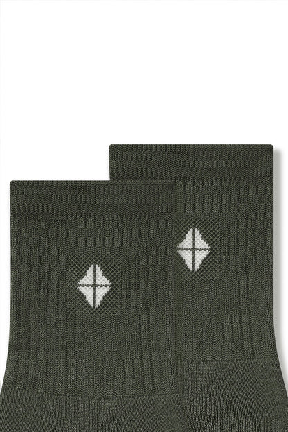 Top part of Adult Crew Socks in Fir with Kyte Baby logo on a white background