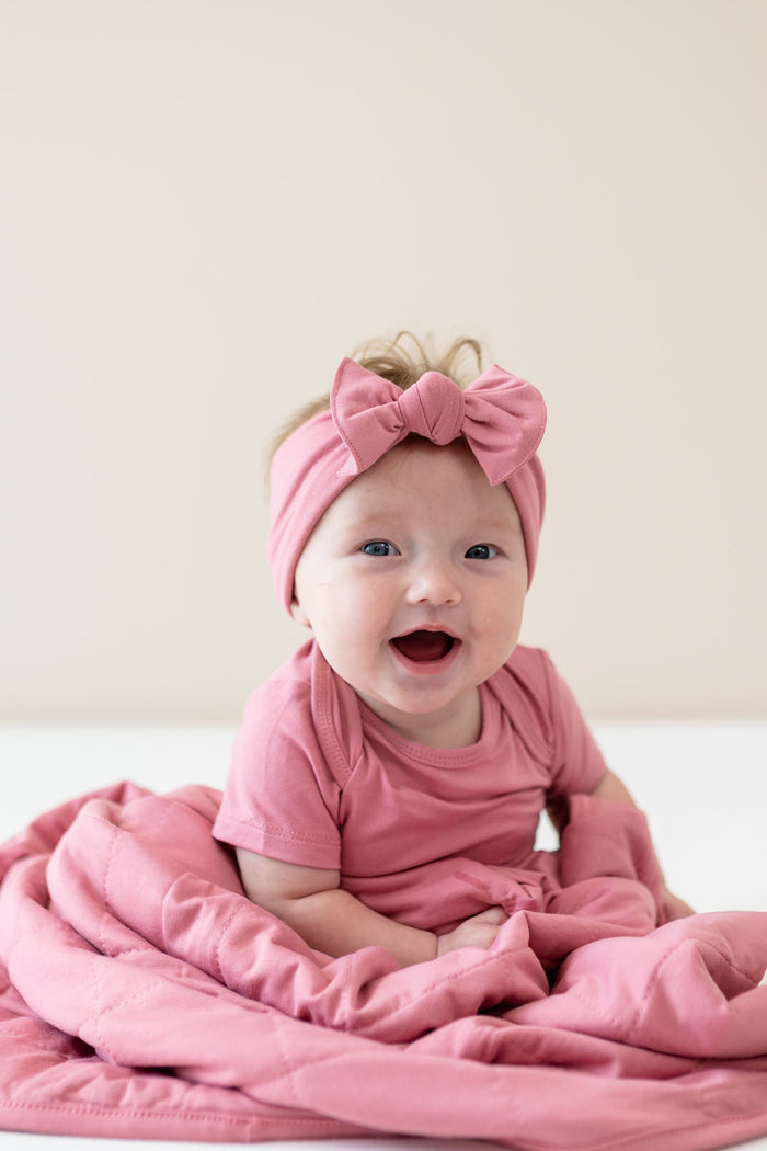 Infant wearing Apple Blossom Bodysuit and Bow wrapped in matching Baby Blanket in Apple Blossom TOG 1.0