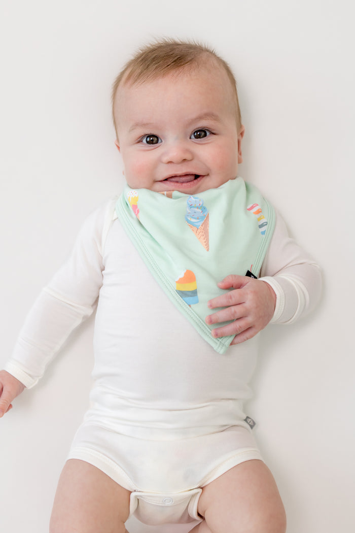 Baby wearing Mint Ice cream print Bib over a white bodysuit on a white background