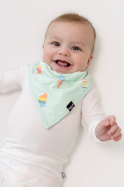 Baby smiling in Mint Ice cream print Bib over a white bodysuit on a white background