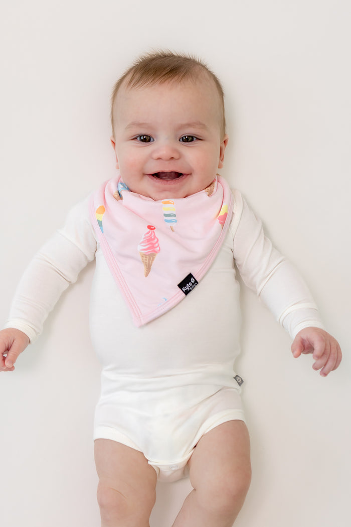 Baby wearing Sakura Ice cream print Bib over a white bodysuit on a white background