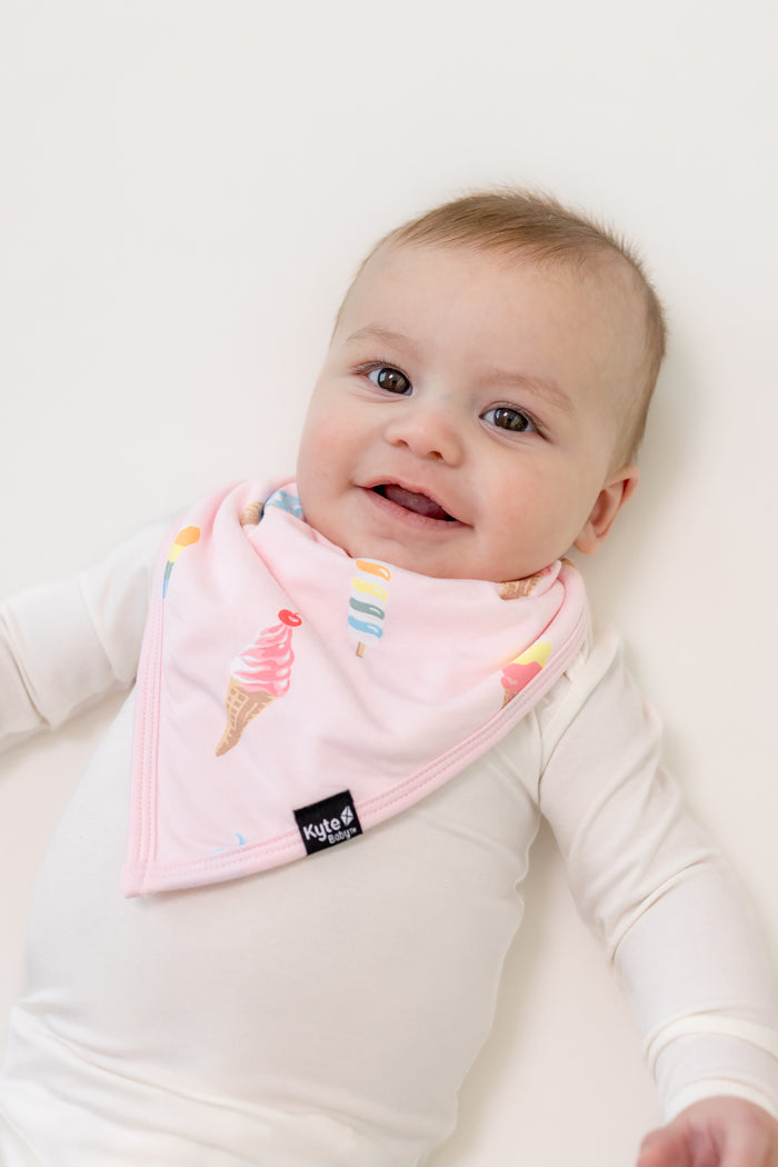 Baby in a Mint Ice cream print Bib on a white bodysuit on a white background