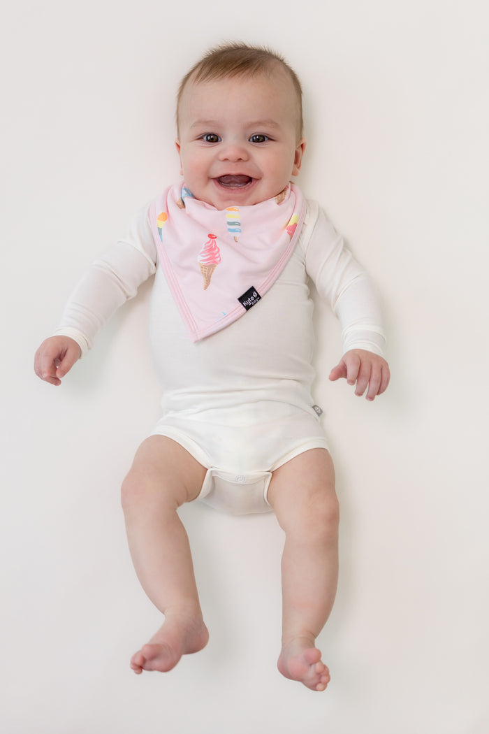 Baby smiling in Mint Ice cream print Bib over a white bodysuit on a white background