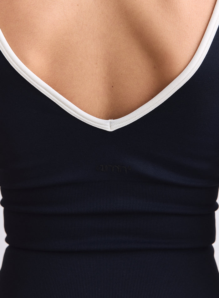Black seamless singlet featuring a deep V-cut back with cream trim and a small aim'n logo. [XS-165cm]