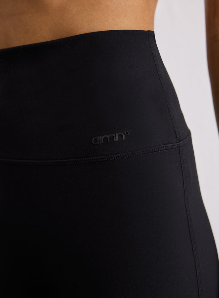 Close-up of the waistband on the Black Sense Straight Leg Petite Tights featuring an aim'n logo