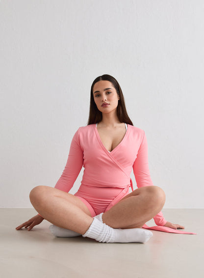Woman sitting cross-legged on the floor wearing a Blush Shape Seamless Wrap Long Sleeve [L-174cm]