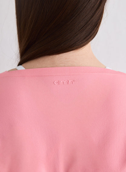 Close-up of the back of the Blush Shape Seamless Wrap Long Sleeve featuring the aim'n logo [L-174cm]