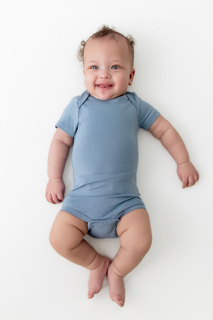 Baby wearing a blue onesie on a white background