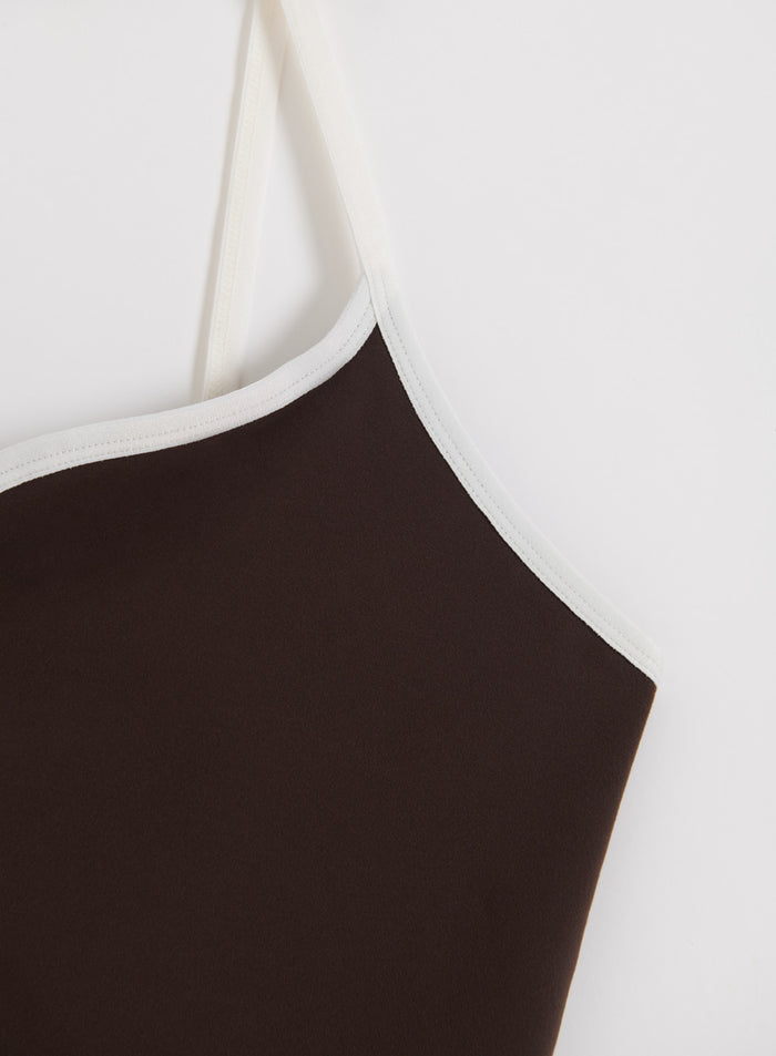 Close-up of a chocolate brown aim'n Sense Contour Singlet with contrast white straps and piping.