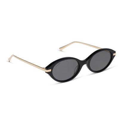 diff eyewear claudine oval sunglasses with a black acetate frame, gold metal temples and grey polarized lenses angled view
