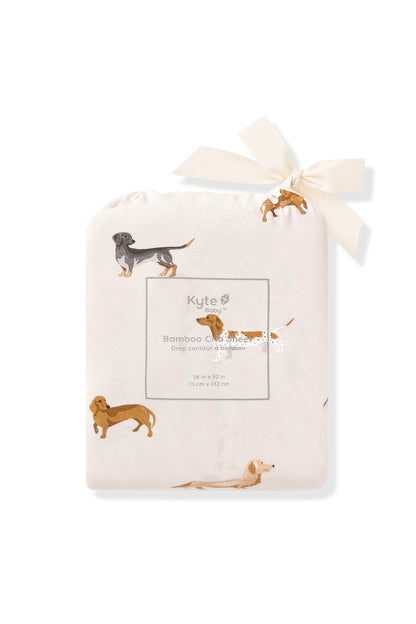 Crib sheet packed in a Dachshund print beige bag on a white background