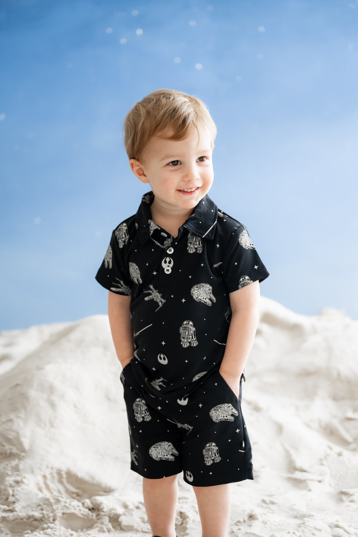 Young boy modeling the Drawstring Short in STAR WARS™ with both hands in the side pockets paired with the matching short sleeve polo tee