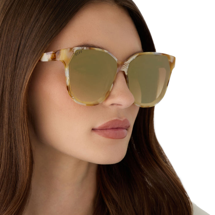 on model - female wearing diff eyewear gia oversized square sunglasses with a gilded tortoise acetate frame and brown gradient with light gold flash lenses angled view