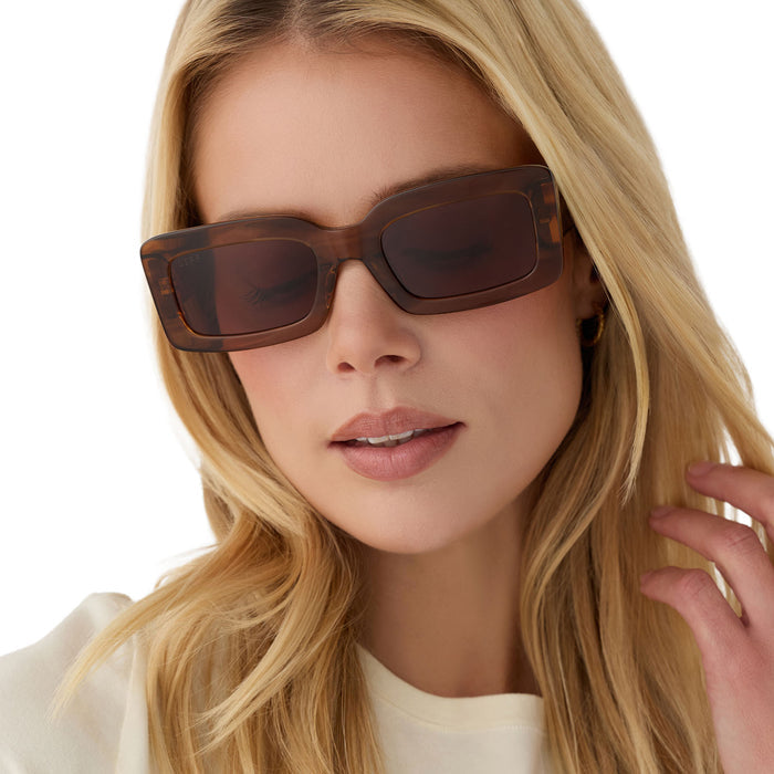 on model - blonde female wearing diff eyewear indy low profile square sunglasses with a tortoise acetate frame and brown lenses front view