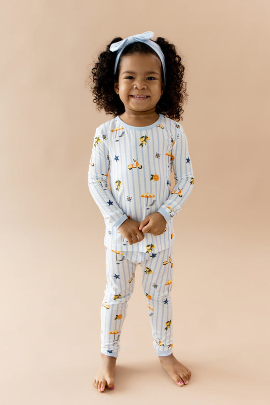 Young girl smiling wearing the Long Sleeve Pajamas in Amalfi Coast with light blue bow