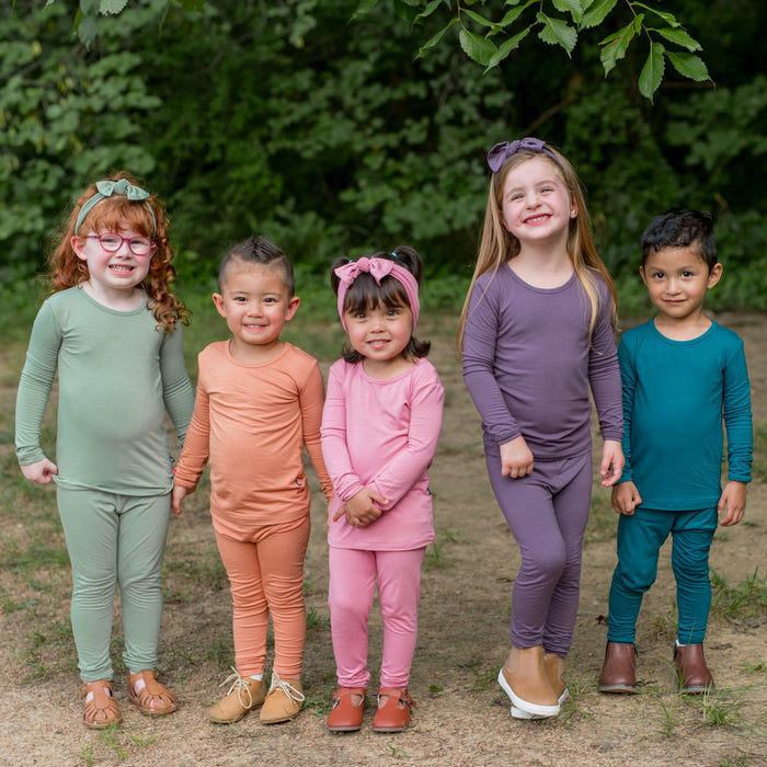 Kids wearing Kyte Baby long sleeve pajamas