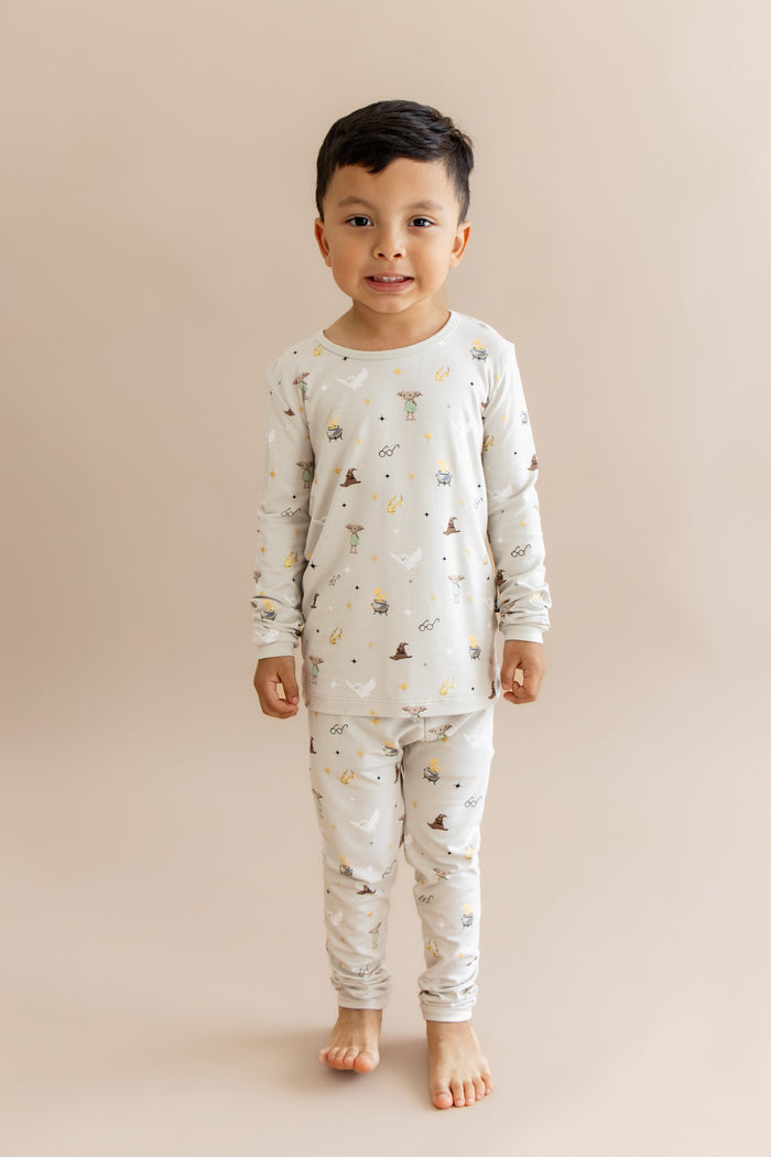 Child wearing a Harry Potter patterned pajama set on a beige background