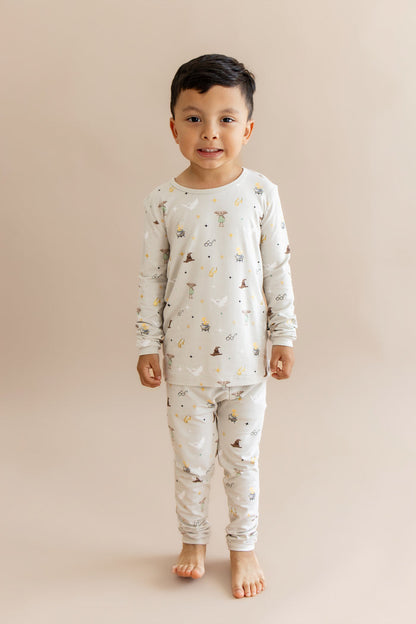 Child wearing a Harry Potter patterned pajama set on a beige background