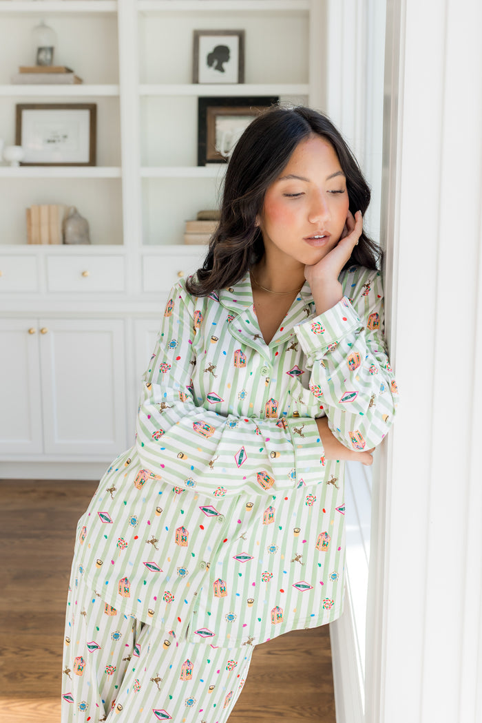 Model posing wearing Long-Sleeved Women's Pajama Set with colorful Harry Potter patterns on a green and white striped fabric.