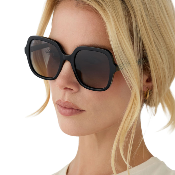 on model - blonde female wearing diff eyewera marlo square oversized sunglasses with a black acetate frame and grey gradient lenses angled view