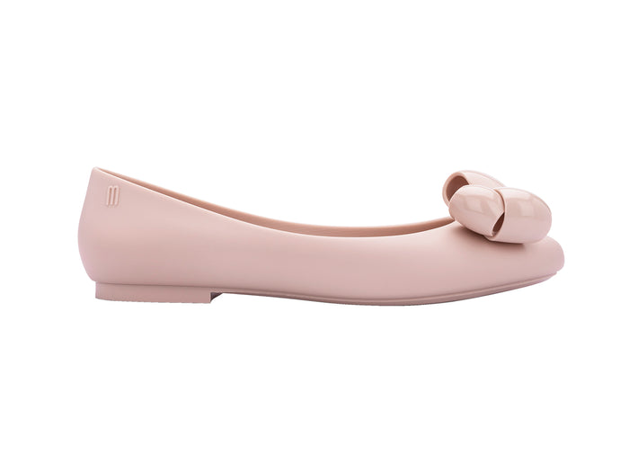 A pair of pink Melissa Doll VIII AD flat shoes with a maxi bow design on the top.