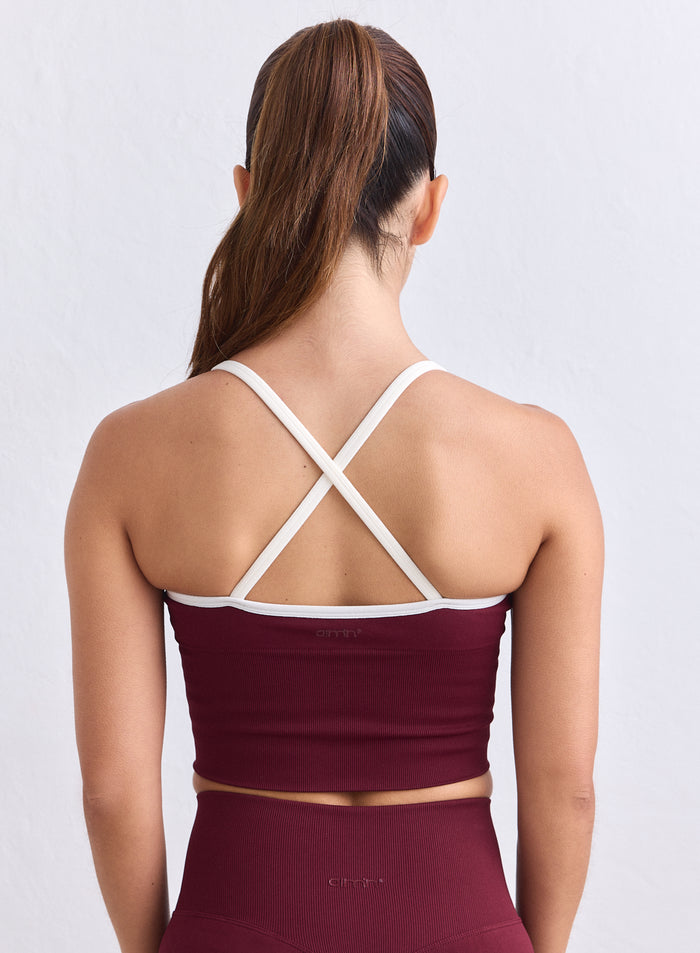 Merlot ribbed seamless bralette featuring white cross-back straps and aim'n logo, viewed from behind. [XS-165cm]