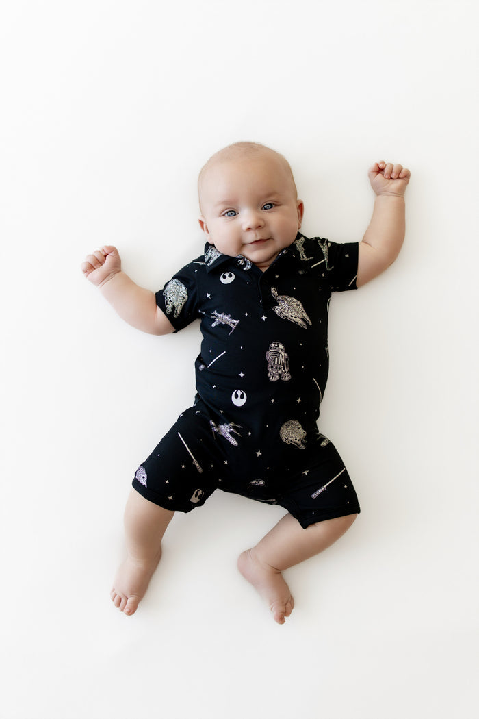 Infant laying on a white surface wearing the Polo Shortall in STAR WARS™