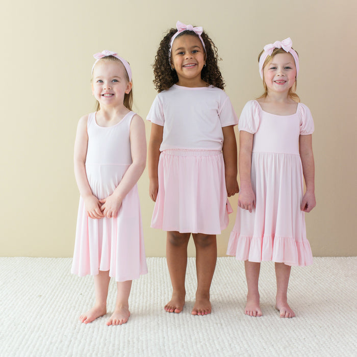 Kids modeling Kyte Baby apparel and accessories in Sakura PInk