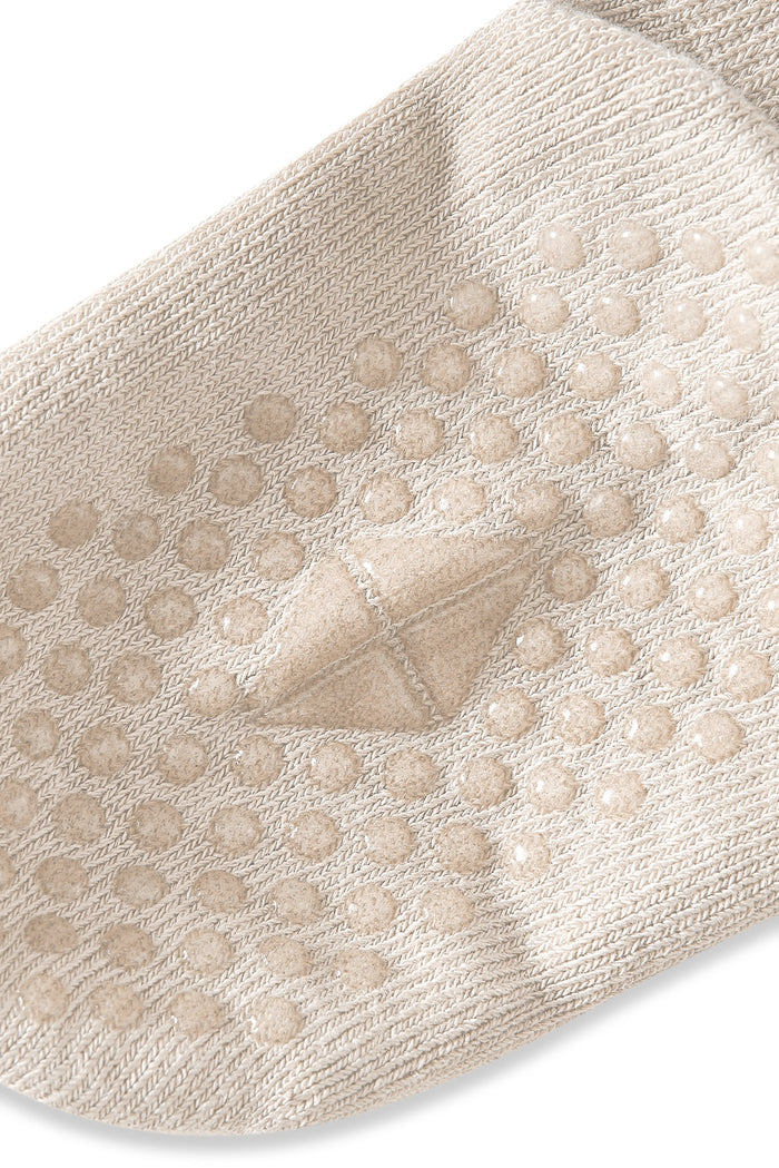 Close up of Quarter Socks in oat with grips on a white background