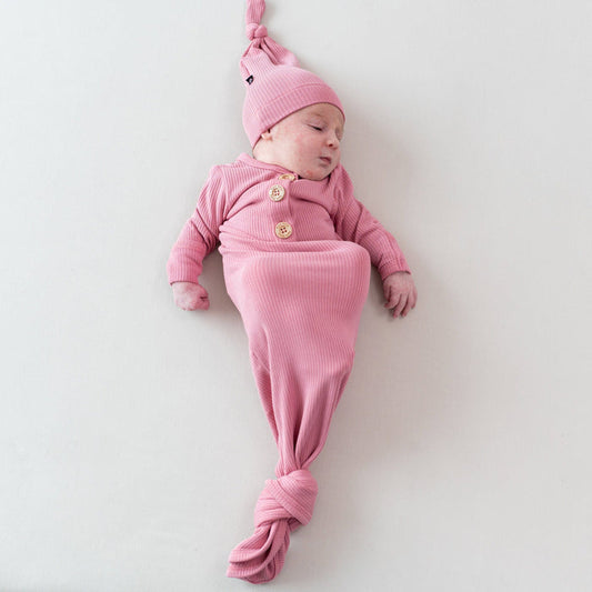 Newborn wearing Kyte Baby Ribbed Knotted Gown with Hat Set in Apple Blossom with wooden buttons