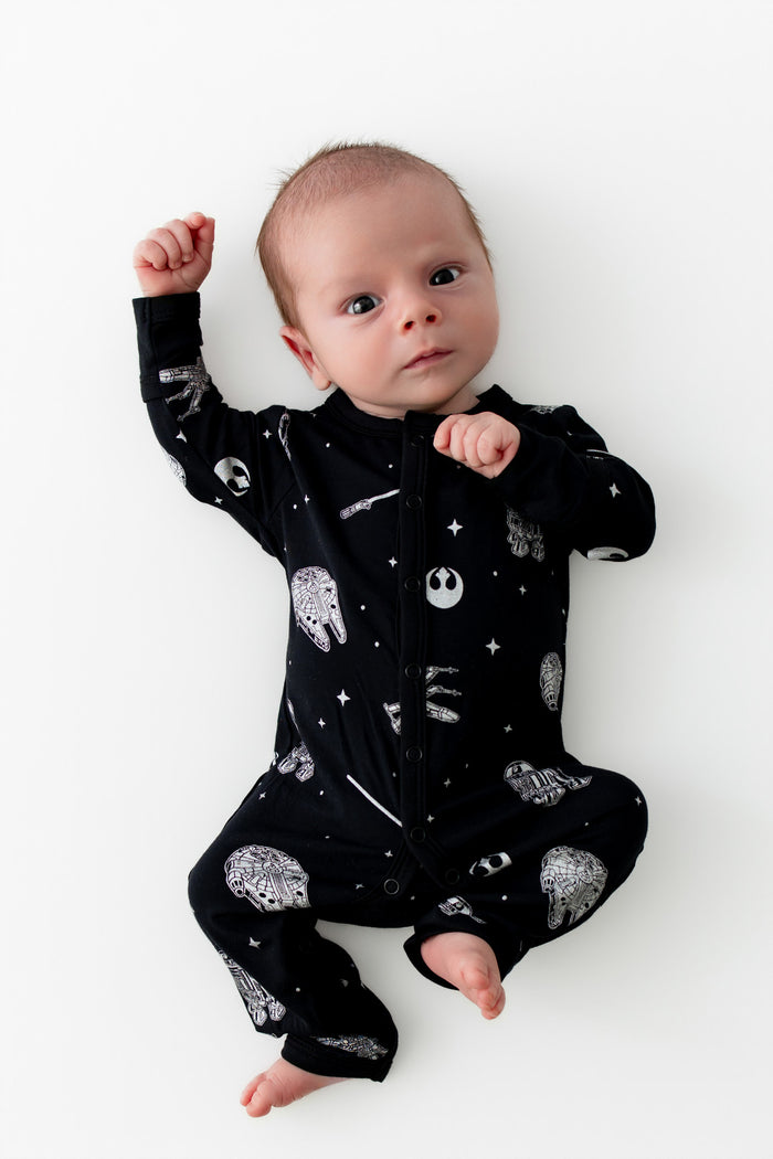 Infant laying on a white surface wearing the Romper in STAR WARS™