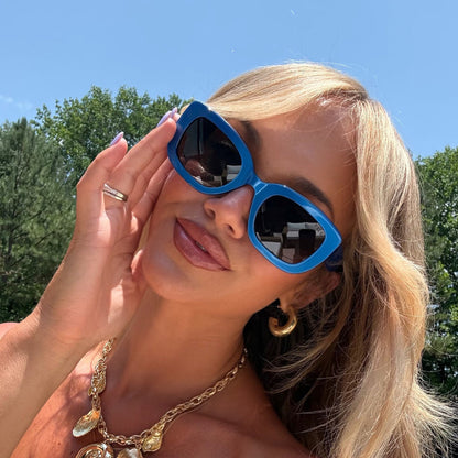 lifestyle - ashley smith wearing blue chunky sunglasses with gold seashell necklace