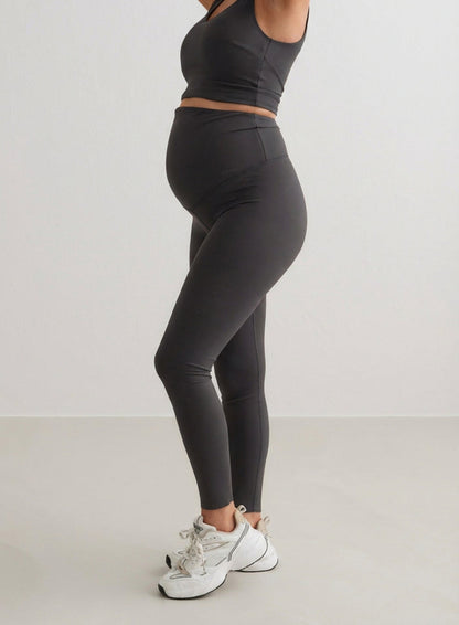Side view of a pregnant woman wearing Shadow Grey Sense Maternity Tights and a matching top by aim'n.