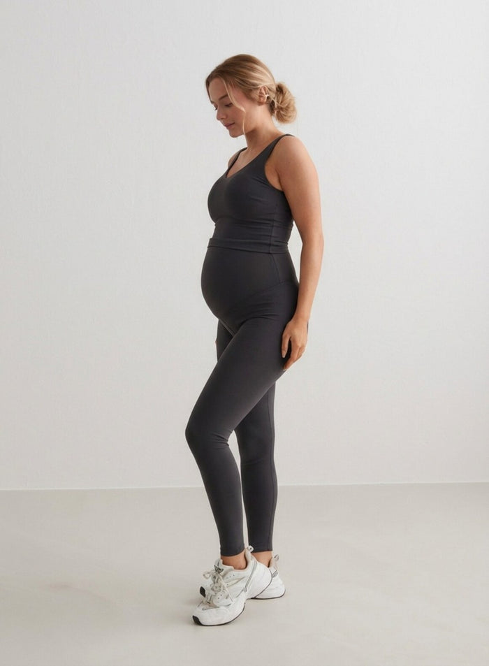A pregnant woman wearing Shadow Grey Sense Maternity Tights and a matching tank top from aim'n.