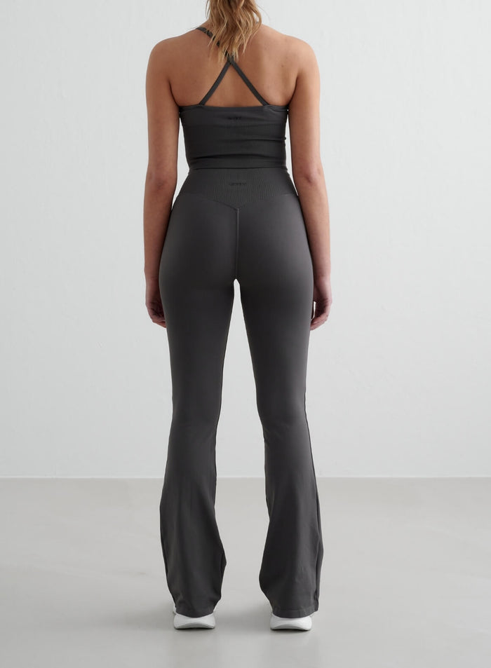 Dark grey aim'n Shape Seamless Flare Tall Tights featuring a high ribbed waist and flared legs from a rear view.