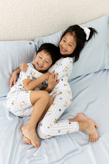 Brother and sister hugging laying in bed wearing the toddler pajamas in Amalfi Coast