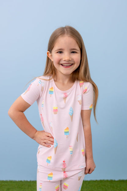 Child posing in short sleeve pajama set in Sakura Ice Cream print on a blue background