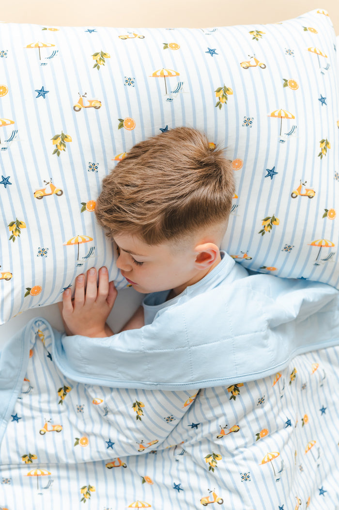 Young boy laying in a bed on a Standard Pillowcase in Amalfi Coast