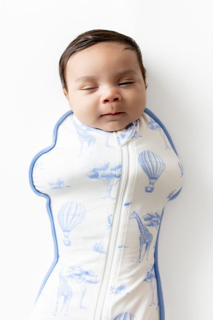 Close up of sleeping newborn wearing the Swaddle Bag in Toile Safari 0.5
