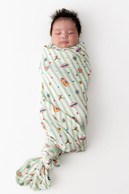 Baby wrapped in a green and white striped Swaddle blanket with colorful Harry Potter patterns on a white background