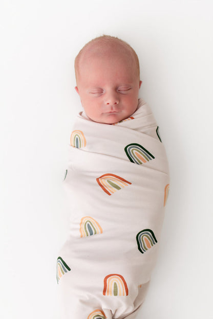Baby sleeping in Swaddle Blanket in Retro Rainbow print on white background