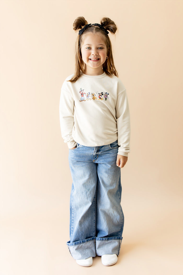 Young girl in mickey and friends sweatshirt and jeans