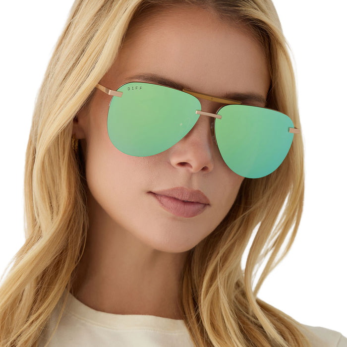 on model - blonde female wearing diff eyewear tahoe oversized aviator sunglasses with a gold metal frame and dew drop blue mirror polarized angled view