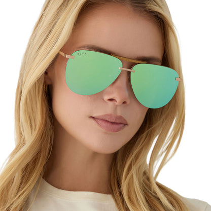 on model - blonde female wearing diff eyewear tahoe oversized aviator sunglasses with a gold metal frame and dew drop blue mirror polarized angled view