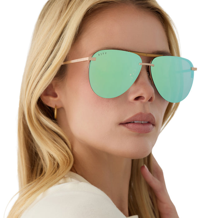 on model - blonde female wearing diff eyewear tahoe oversized aviator sunglasses with a gold metal frame and dew drop blue mirror polarized front view