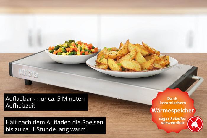 Ein Teller mit gerösteten Kartoffelspalten und eine Schüssel mit gemischtem Gemüse stehen auf der Unold Wärmespeicherplatte Elena, einem rechteckigen Warmhaltetablett, das für seine keramische Wärmespeicherung und kabellose Nutzung bekannt ist, wie im begleitenden deutschen Text beschrieben.