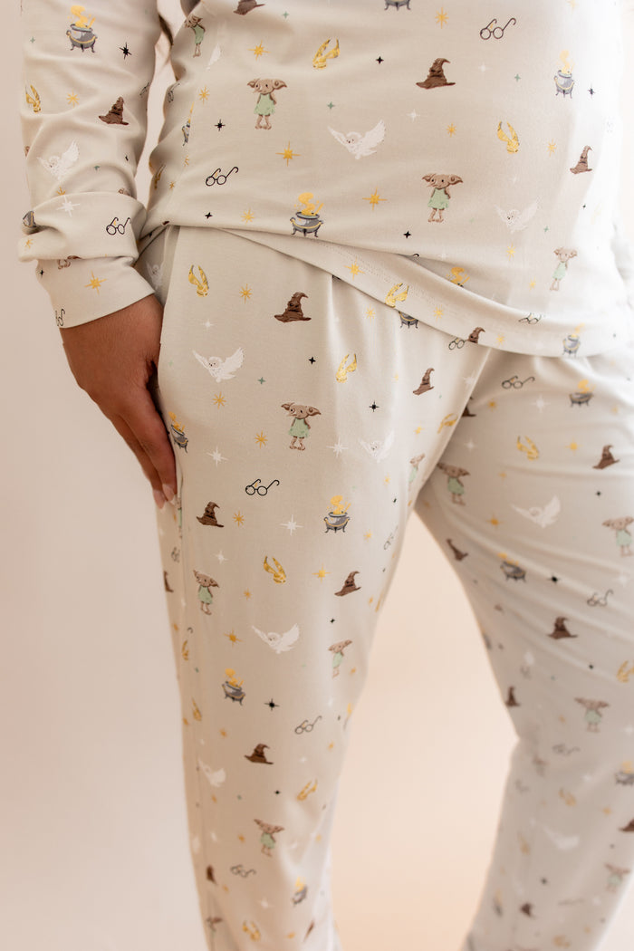 Women wearing a beige Harry Potter patterned jogger pajama with pockets on a beige background