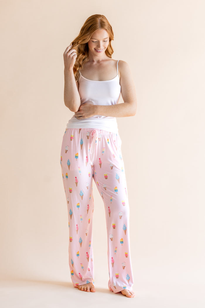 Model posing in Pink Women's Lounge Pants in Ice Cream print under white camisole on beige background